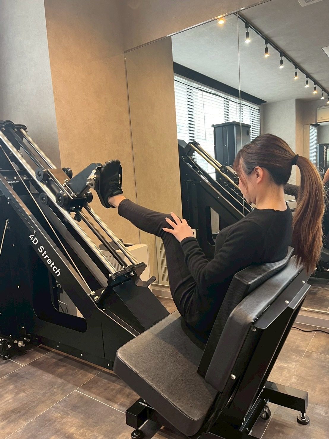女性会員様が 4D ストレッチマシンを使っている